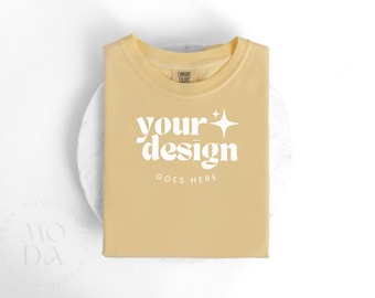 May include: A yellow t-shirt with a white graphic that says "your design goes here" and a small star.
