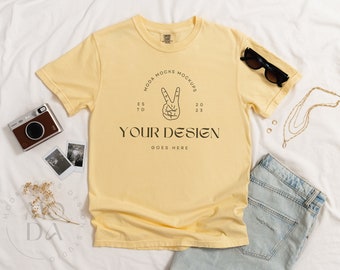 May include: A yellow t-shirt with a peace sign graphic and the text "MODA MOCKS MOCKUPS" and "YOUR DESIGN GOES HERE".