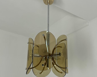 May include: A vintage chandelier with a gold-toned canopy and a chrome stem. The light fixture features amber-coloured, petal-shaped glass shades and curved metal arms. The design is reminiscent of mid-century modern lighting.