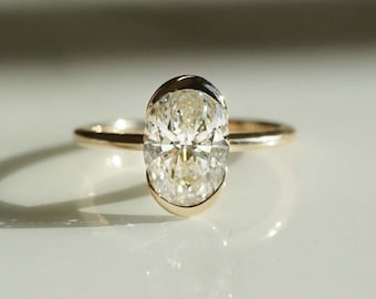 Può includere: Un anello di fidanzamento in oro con un grande diamante di forma ovale.