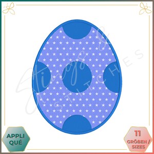 May include: A blue egg-shaped applique design with a white star pattern and three large blue circles. The design is outlined in blue. The image includes the text "APPLIQUÉ" and "11 GRÖBEN / SIZES".