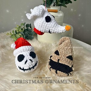 May include: Crocheted Christmas ornaments depicting characters from The Nightmare Before Christmas. Includes Zero, Jack Skellington with a Santa hat, and Oogie Boogie. The ornaments are white, black, red, and tan. The text "Christmas Ornaments" is at the bottom.