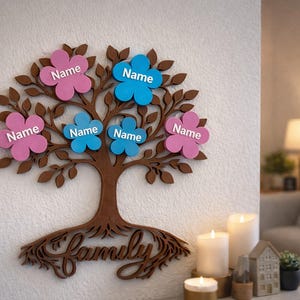 Puede incluir: Decoraci&oacute;n de pared de &aacute;rbol geneal&oacute;gico de madera con tronco y ramas marrones. Etiquetas con nombres en forma de flor rosa y azul unidas a las ramas. La palabra "Family" est&aacute; en la base del &aacute;rbol.