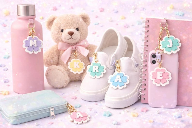 May include: A collection of pastel-colored accessories, including a pink water bottle, a teddy bear, white sneakers, a phone, and a pencil case. Each item has a flower-shaped charm with a letter. The background is decorated with star-shaped confetti.