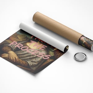 May include: A print of a classic painting with the text "Feel the Progress" in pink. The print is next to a rolled-up poster, a white tube, and a silver button. The print is on a white surface.