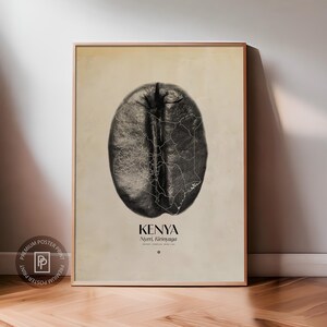 Puede incluir: Impresión enmarcada que presenta una ilustración detallada de un grano de café. El interior del grano muestra un mapa de Kenia, con el texto "Kenya, Nyeri, Kirinyaga" debajo. La impresión tiene una paleta de colores neutros y se muestra sobre un fondo claro.
