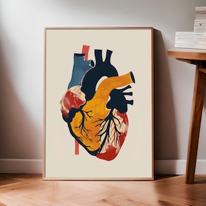 May include: Anatomy art print featuring a stylized human heart illustration. The heart is depicted in shades of red, yellow, orange, and blue, with a beige background. The artwork is framed in a light brown wooden frame, suitable for medical students or science enthusiasts.