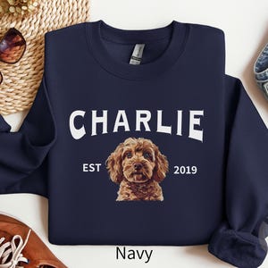 May include: Navy blue sweatshirt with a white graphic of a dog with the text "CHARLIE EST 2019".