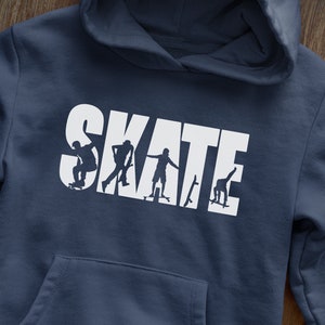 Könnte beinhalten: Ein marineblauer Hoodie mit einer weißen Grafik des Wortes "SKATE" mit Silhouetten von Skateboardern innerhalb der Buchstaben.