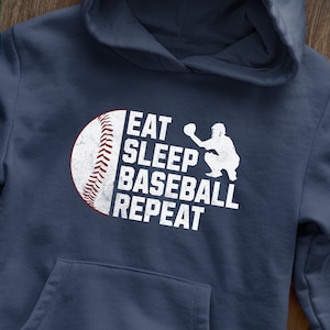 May include: A navy blue hoodie with a white baseball graphic and the text "Eat Sleep Baseball Repeat".