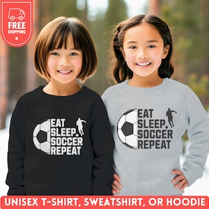 May include: Two children wearing gray and black sweatshirts with the text "Eat Sleep Soccer Repeat" and a soccer ball graphic.