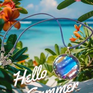 May include: A round pendant necklace with a blue and purple design, suspended from a lilac cord. The pendant is set against a backdrop of tropical flowers and foliage, with the words "Hello Summer" in white script.