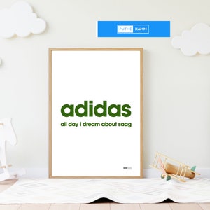 Könnte beinhalten: Ein gerahmter Druck mit weißem Hintergrund und einem grünen Adidas-Logo. Der Text unter dem Logo lautet "all day I dream about saag".