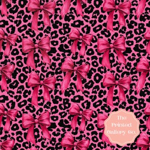 May include: A repeating pattern featuring bright pink bows and black leopard print spots on a pink background. The bows have long, flowing ribbons. The overall design is bold and eye-catching, suitable for fabric or wallpaper.