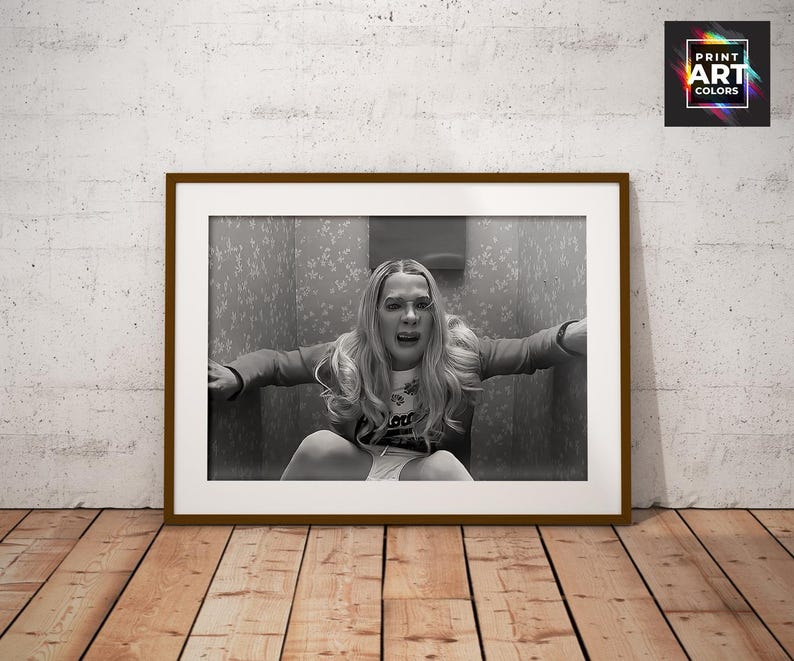Puede incluir: Impresi&oacute;n enmarcada en blanco y negro que representa a una persona en apuros, sentada en un ba&ntilde;o. La impresi&oacute;n est&aacute; en un marco marr&oacute;n, sobre una pared blanca y un suelo de madera. La impresi&oacute;n tiene el texto "Print Art Colors" en la esquina superior derecha.