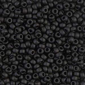 May include: A collection of small, round, matte black beads with a uniform shape and a central hole. The beads are densely packed together, creating a textured surface of dark, opaque material with a consistent finish across every individual bead.