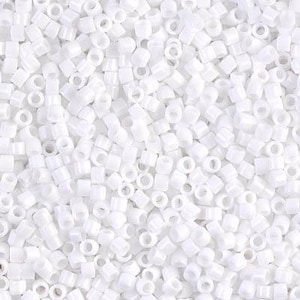 Può includere: Una grande quantità di piccole perline di plastica bianche con un foro al centro. Le perline sono disposte in uno schema casuale.