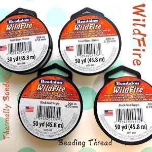 May include: Four spools of Beadalon WildFire thermally bonded bead weaving thread. The spools are black with orange and white labels. The labels display the thread's specifications, including the diameter in inches and the length of 50 yards.