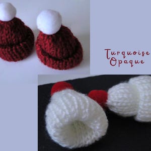 Könnte beinhalten: Zwei Miniatur-Strickmützen mit weißen Bommeln. Die Hüte sind tiefrot. Das Bild zeigt auch eine Nahaufnahme einer weißen Mütze mit rotem Bommel. Der Text "Turquoise Opaque" befindet sich im Bild.
