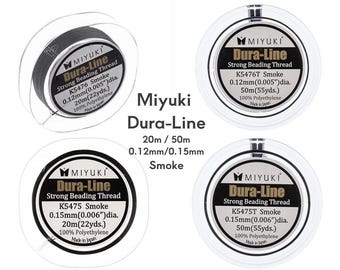 May include: Four clear plastic spools of Miyuki Dura-Line strong beading thread in smoke color. Labels display specifications including 0.12mm (0.005 inch) or 0.15mm (0.006 inch) diameters and lengths of 20m (22 yards) or 50m (55 yards) of polyethylene.
