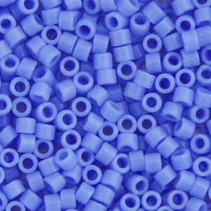 May include: A close-up shot of numerous light blue plastic beads. Each bead is cylindrical with a hole running through the center. The beads are scattered, creating a textured surface. These beads are commonly used for crafting and creating pixel art.