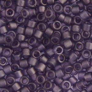May include: Close-up of a pile of small, cylindrical beads in a muted purple color. The beads have a metallic sheen and a hole running through the center, suitable for stringing. These beads are ideal for jewelry making and crafting projects.