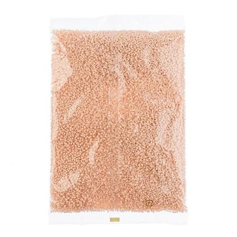May include: A clear plastic bag filled with small, light peach-colored beads.