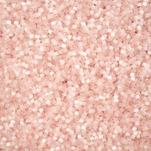 May include: A close-up shot of a pile of small, translucent, light pink, cylindrical beads. The beads are scattered, creating a textured surface. The beads are uniform in shape and size, and appear to be made of plastic.