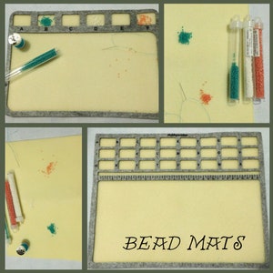 Peut inclure: Un tapis à perles gris avec une surface en feutre blanc. Le tapis est composé d'une grille de carrés avec des lettres et des chiffres imprimés dessus. Le tapis est intitulé "Bead Mats".