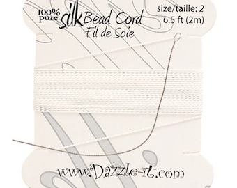 May include: White silk bead cord on a card with the text "100% Pure Silk Bead Cord Fil de Soie" and "size/taille: 2 6.5 ft (2m)" and the website address "www.Dazzle-it.com".