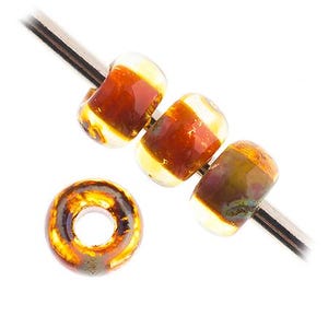 Peut inclure: Quatre perles en verre de couleur brune et jaune. Les perles sont rondes et ont un trou au centre. Elles sont enfilées sur un fil d'argent.