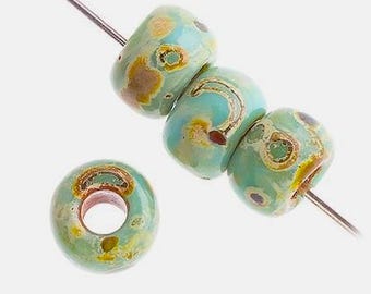 May include: Four turquoise blue glass beads with brown and yellow speckles. The beads are strung on a silver wire.