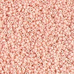 May include: A close-up image of a large quantity of small, round, light pink beads. The beads are opaque and have a smooth, glossy finish.