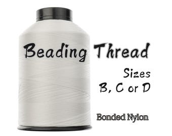 May include: A white spool of beading thread with a black cap. The text "Beading Thread" is displayed on the spool, along with "Sizes B, C or D" and "Bonded Nylon".