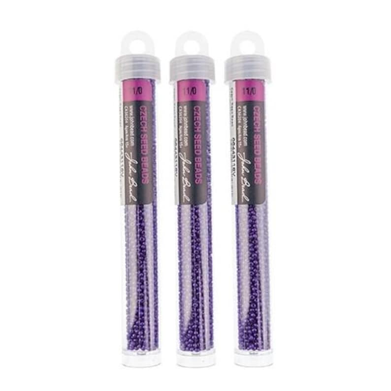 K&ouml;nnte beinhalten: Drei durchsichtige R&ouml;hrchen gef&uuml;llt mit violetten tschechischen Rocailles. Die R&ouml;hrchen sind mit "1/0" und "11/0" beschriftet und stammen von der Marke "Jula Bead".