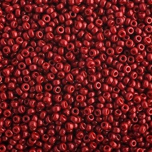 May include: A close-up view of a large quantity of small, round, red beads. The beads are all the same size and shape, and they are arranged in a random pattern.
