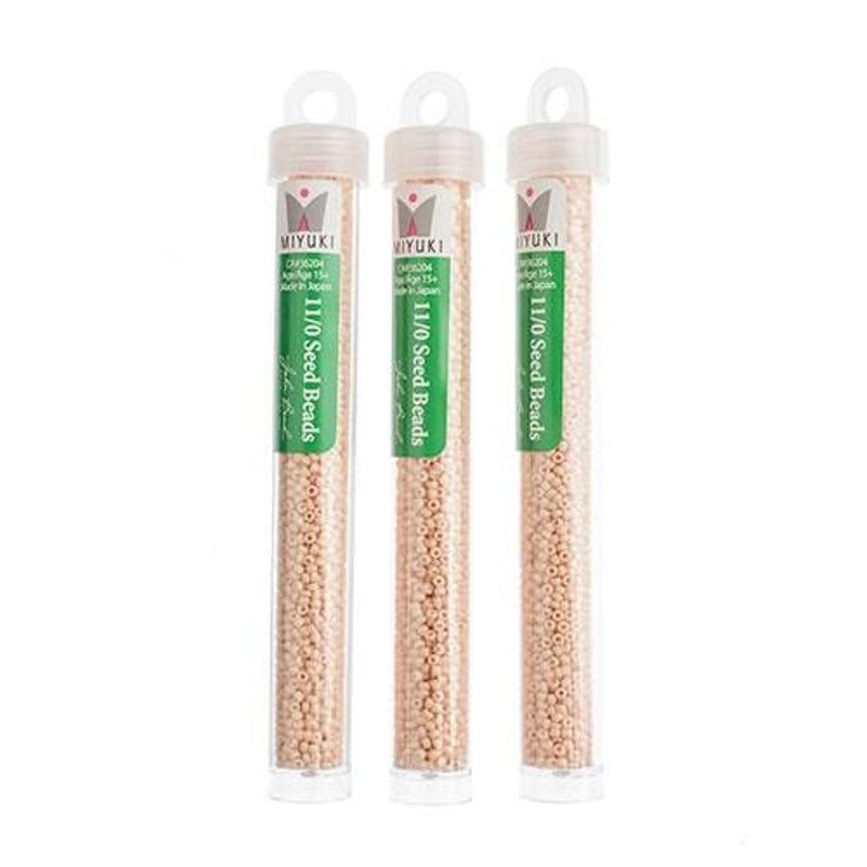 May include: Three clear plastic tubes filled with small, light beige seed beads. Each tube has a green label with the text "MIYUKI 11/0 Seed Beads".