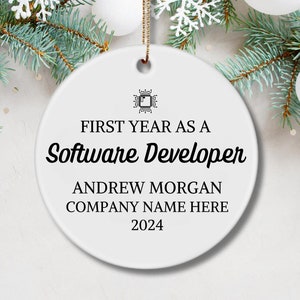 May include: White round ornament with black text that reads "First Year as a Software Developer", "Andrew Morgan", "Company Name Here", and "2024".