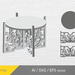 Op de afbeelding: Een grijze, decoratieve, ronde taartstandaard met een bloemenmotief. De standaard is gemaakt van hout en heeft een ronde bovenkant en vier poten. De standaard wordt getoond op een witte houten achtergrond.