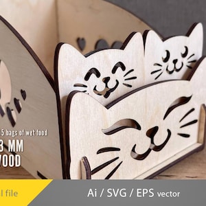 May include: Wooden cat-themed storage box with a light brown finish. The box features cut-out cat faces and paw prints. Text on the side reads "holds 12-15 bags of wet food FOR 3 MM PLYWOOD". The design is available as a digital file.