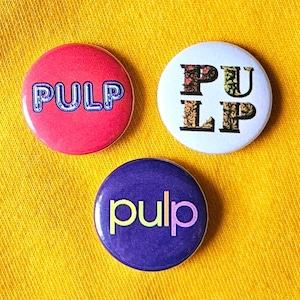 Pulp set of three 25mm (1 inch) button pin badges with designs influenced by the Britpop combo's logos and sleeve art.