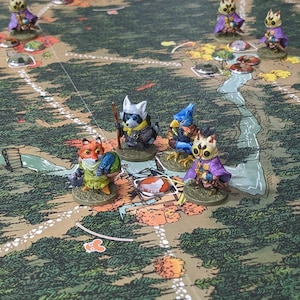 May include: A collection of painted miniature animal figurines placed on a printed board game map. The figures include a fox in a green coat, a raccoon with a staff, a blue bird-like creature, and several small owl-like characters in purple cloaks.