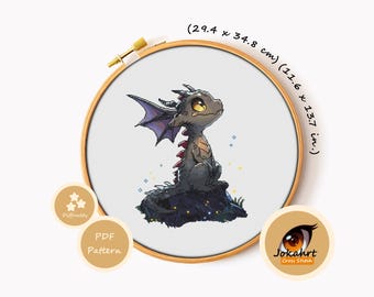 May include: A cross stitch pattern in a wooden hoop featuring a small grey dragon with purple wings sitting on a dark rock. The design measures 11.6 x 13.7 inches. Text includes Difficulty, PDF Pattern, and the brand name Jokahrt Cross Stitch.