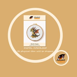 Pu&ograve; includere: Uno schema a punto croce in download digitale intitolato Earth Dragon di Jokahrt Cross Stitch. Il disegno raffigura un piccolo drago verde e arancione con ali seduto a terra, mostrato all'interno di un telaio da ricamo in legno su un cartoncino bianco.