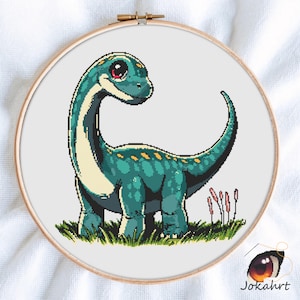 Könnte beinhalten: Ein Kreuzstich-Stickrahmen mit einem teal-farbenen Dinosaurier mit gelben Punkten, der in grünem Gras steht. Der Dinosaurier hat einen langen Hals und Schwanz, mit einem freundlichen Gesichtsausdruck. Der Rahmen ist aus Holz und vor weißem Hintergrund.