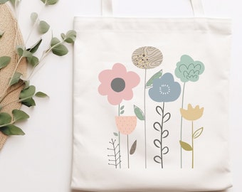 May include: A white canvas tote bag with a floral design. The flowers are pink, blue, yellow, and green. The bag has two handles.