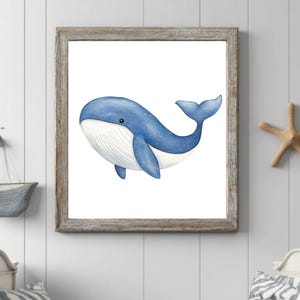 以下が含まれることがあります： 白い斑点と白い腹を持つ青いクジラの水彩画。クジラは右に泳いでおり、小さな白い目があります。クジラは素朴な木製の額縁に入っています。