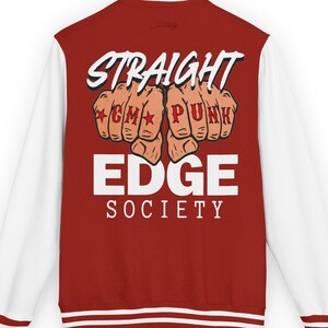 May include: A red and white varsity jacket featuring the text "STRAIGHT EDGE SOCIETY". The jacket has white sleeves and a red body with white stripes on the cuffs and collar. The graphic includes fists with the words "CM PUNK" in a bold font.