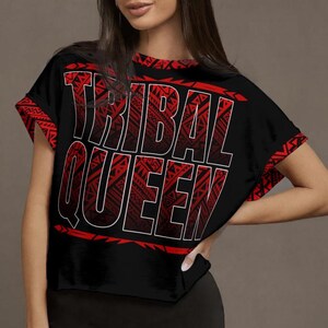 May include: Black crop top with red tribal design accents and the text "TRIBAL QUEEN" in red with a white outline. The sleeves and neckline feature a matching red tribal pattern. The shirt is a casual style.