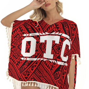May include: A red and black patterned poncho with the letters "OTC" in white. The poncho has a V-neck and is trimmed with white fringe. The pattern includes geometric shapes and tribal designs.